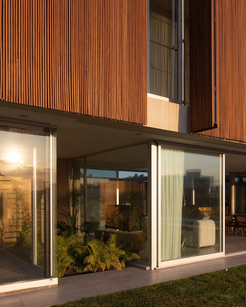 Sliding glass doors with sheer curtains and interior lighting visible at dusk