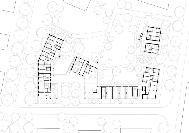 Ground floor plan showing residential wings with central corridor and surrounding mature trees