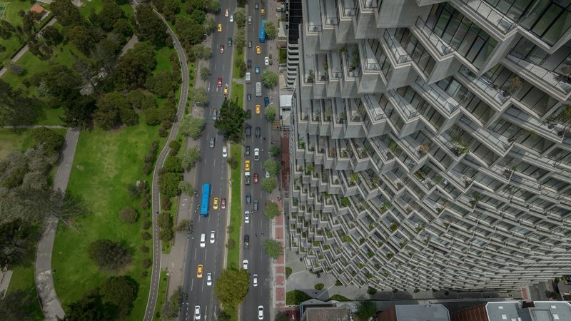 Aerial view of the terraced facade beside a tree-lined avenue with passing traffic