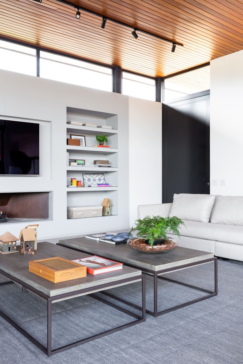 Living space with timber slatted ceiling and recessed shelving beneath clerestory windows