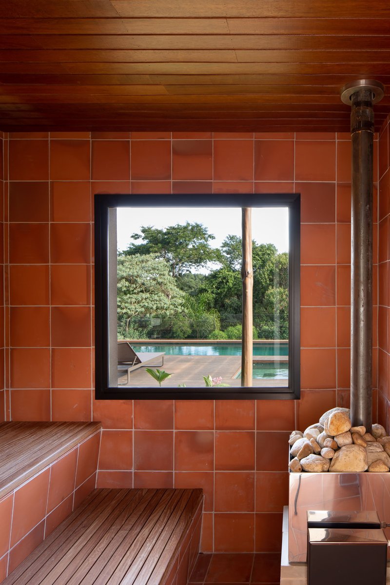 Sauna interior with terracotta tile walls and window framing view to pool