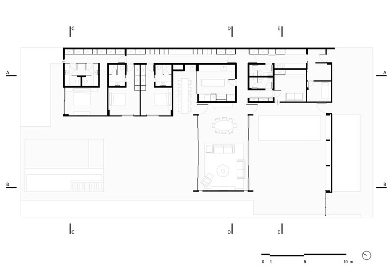 Floor plan drawing showing L-shaped layout with service wing, central living area and pool terrace