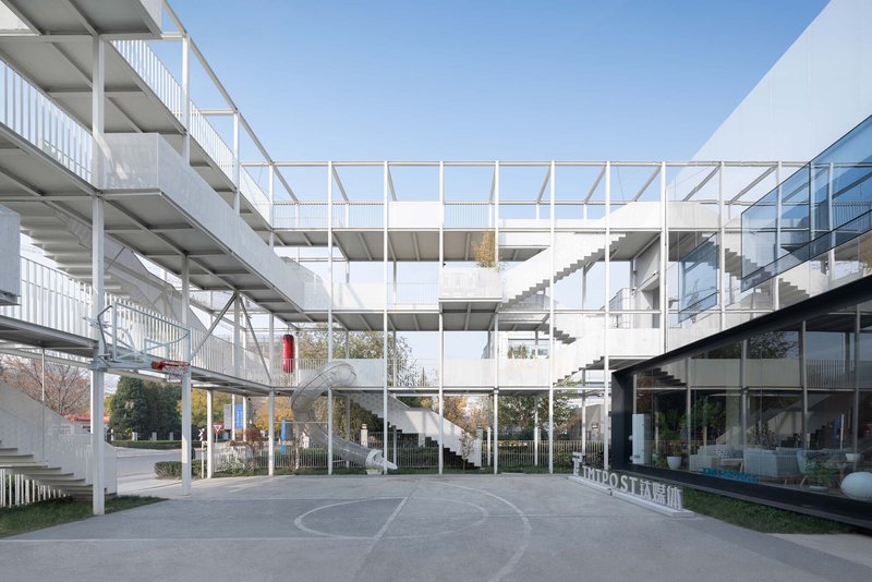 White steel frame structure with exposed floors and staircases surrounding a central courtyard