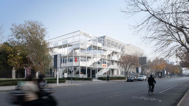 Street view of the white structural frame with cyclists and pedestrians passing in autumn