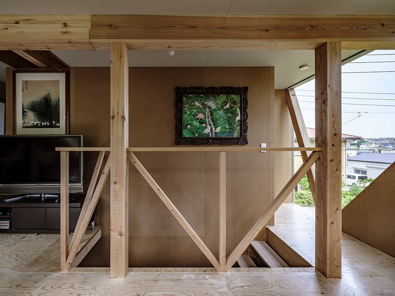 Diagonal timber balustrade with exposed posts framing a concrete wall and view to the harbor beyond