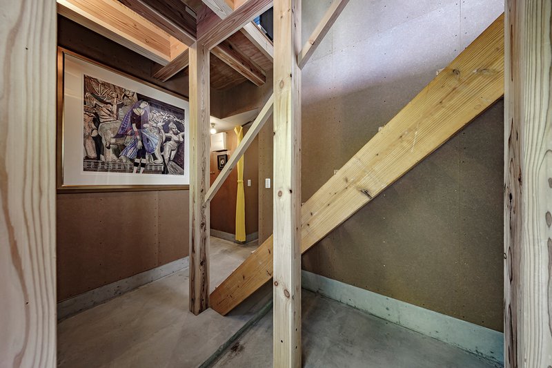 Landing view showing diagonal timber stringer against concrete walls with exposed structural framing above