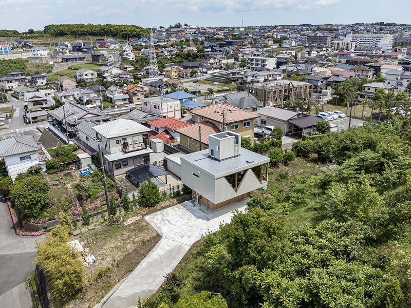 Aerial view of the corrugated metal house with triangular windows nestled in a dense suburban neighborhood