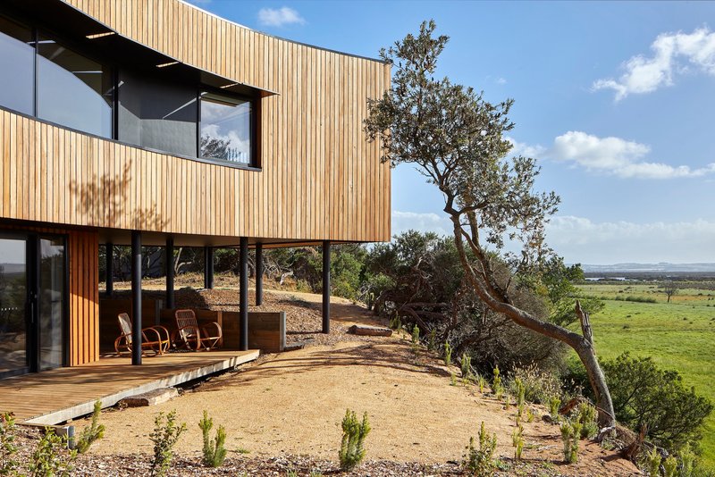 Timber deck wrapping around the glazed living space with views across the open landscape beyond