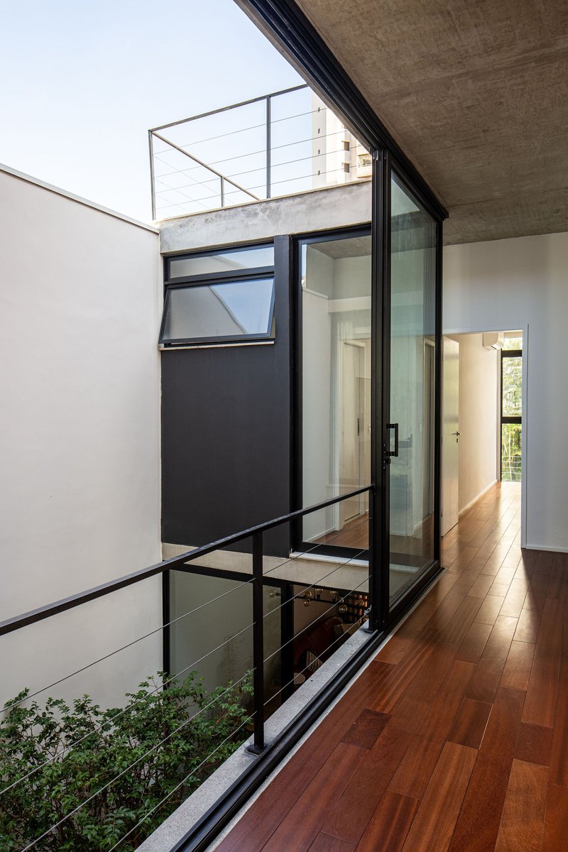 Interior courtyard with planted bed viewed through floor-to-ceiling glass sliding doors