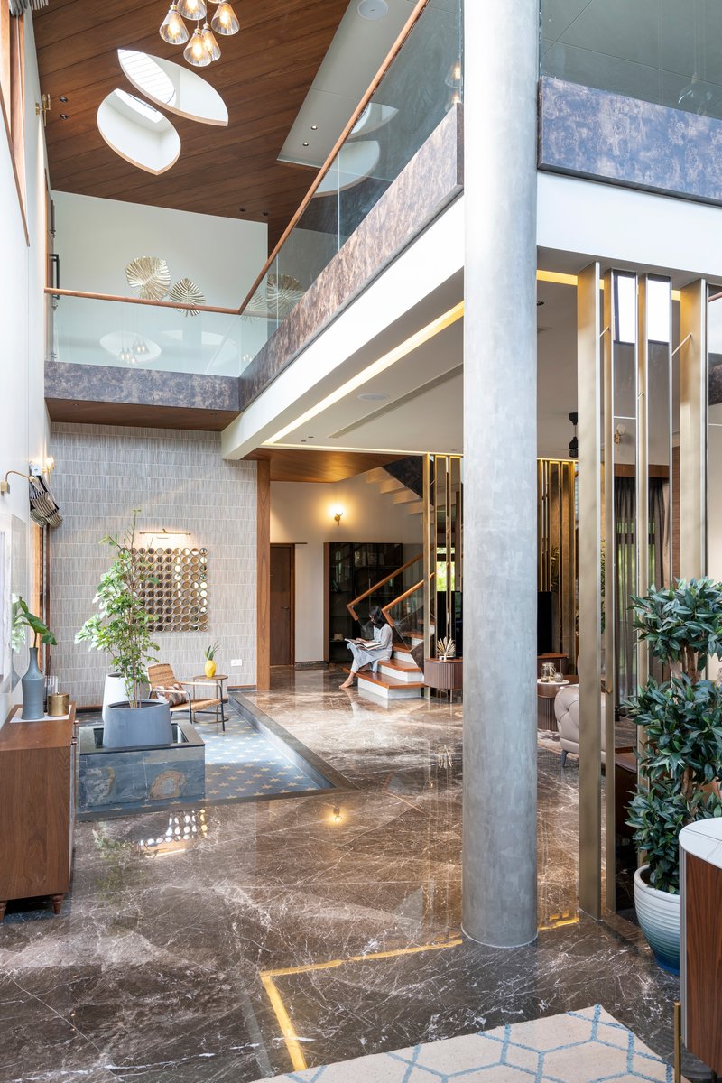 Interior atrium with exposed concrete column and timber ceiling beneath a glazed opening above