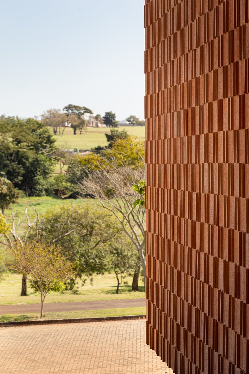 Vertical timber slat facade framing a view of the surrounding parkland and trees