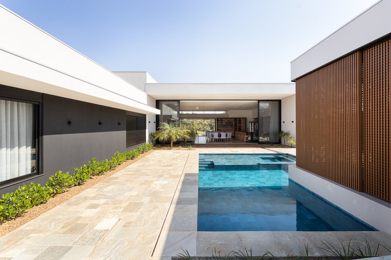 Courtyard pool with stone deck, vertical timber screen wall and shaded seating area beyond
