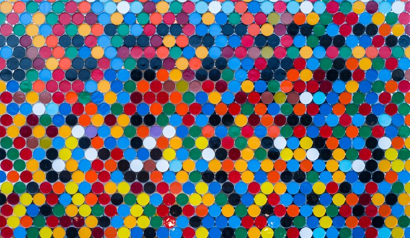 Close-up of the polychrome circular ceramic disc cladding system with visible joints