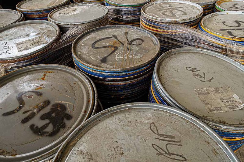 Stacked paint can lids with handwritten markings used as facade modules during construction