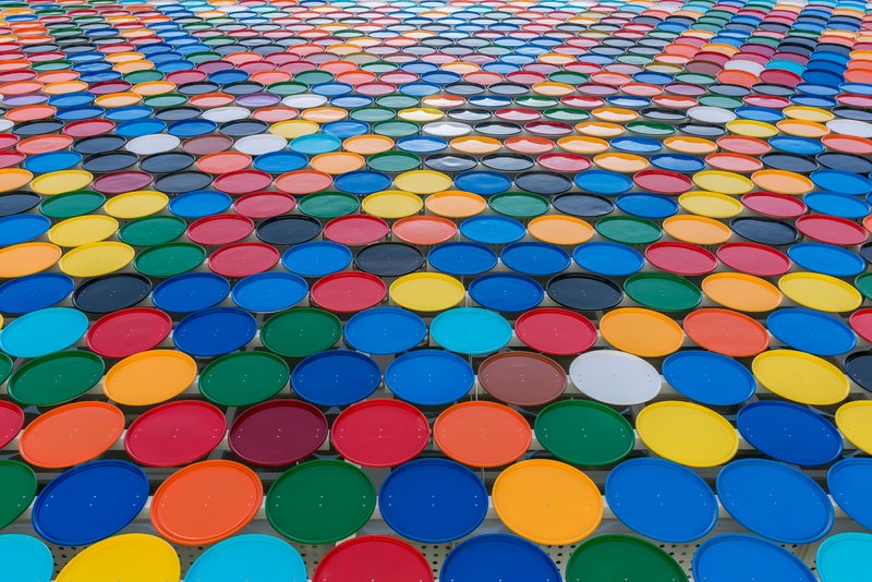 Roof view of multicolored circular glass panels arranged in overlapping rows creating patterned canopy