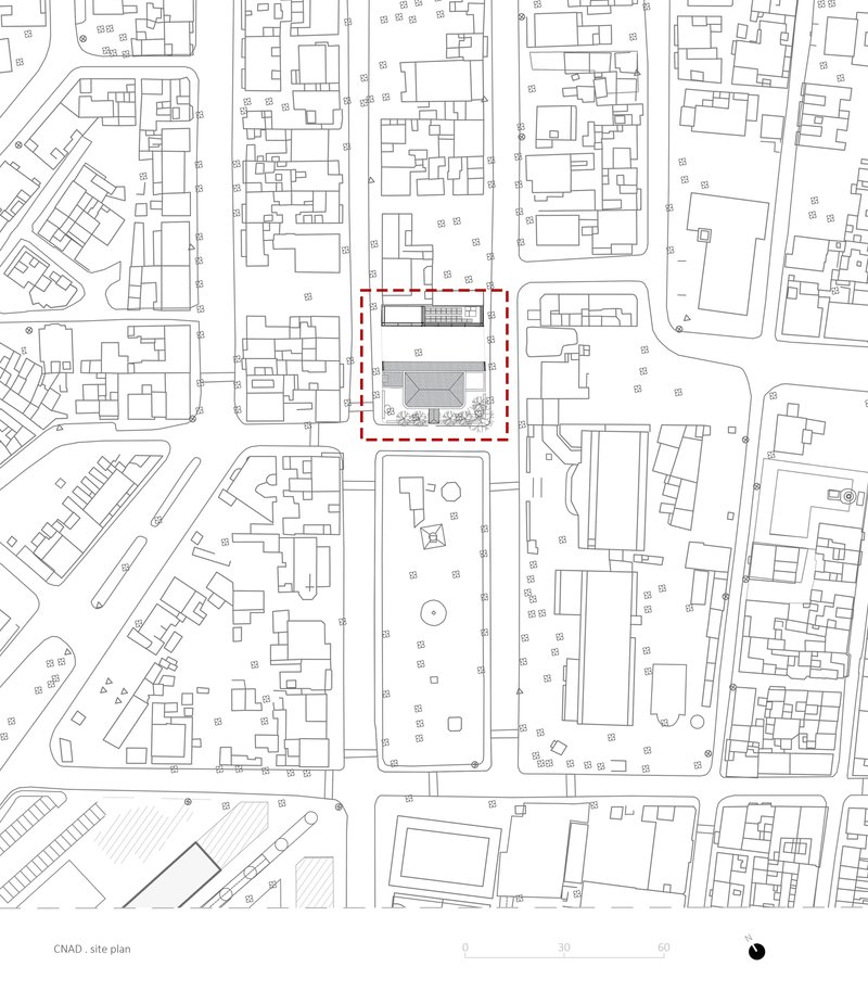 Site plan drawing showing a rectangular building footprint outlined in red within the surrounding urban block