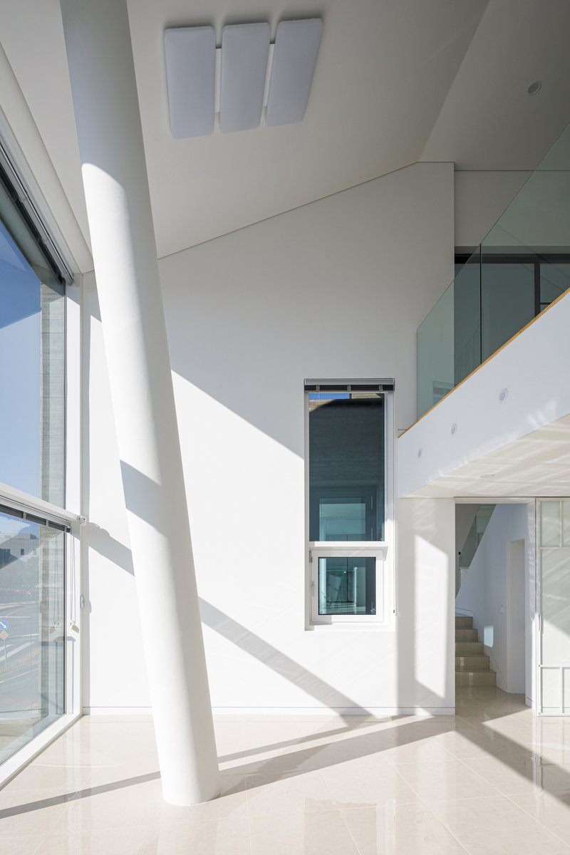 Interior corner with a white structural column and vertical window in bright morning light
