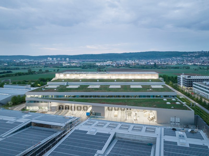 Aerial view of the industrial complex with photovoltaic arrays on rooftops at dusk