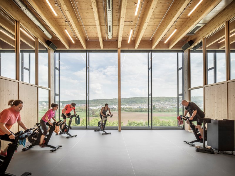 Training room with timber ceiling beams and floor-to-ceiling windows overlooking fields