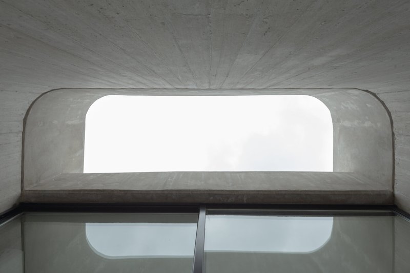 Interior view up through curved concrete vault with rounded window opening overhead