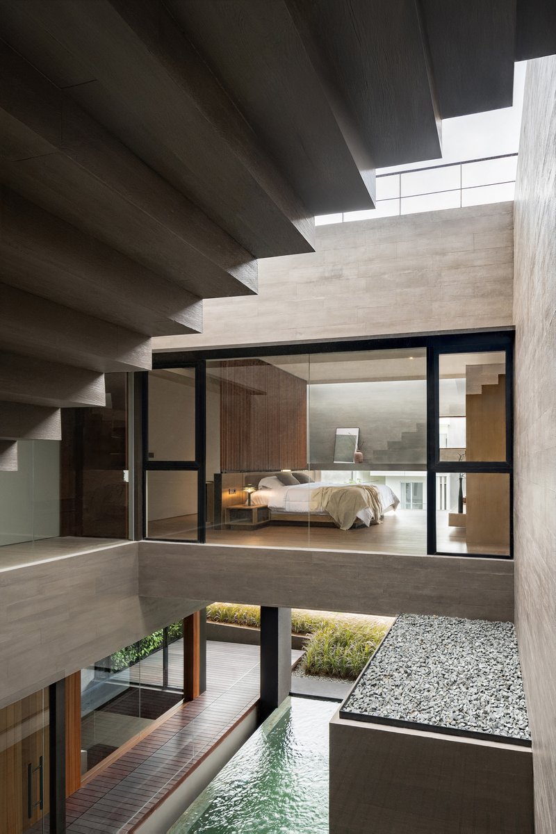 Interior courtyard showing cantilevered bedroom, exposed concrete stairs and pool with gravel bed