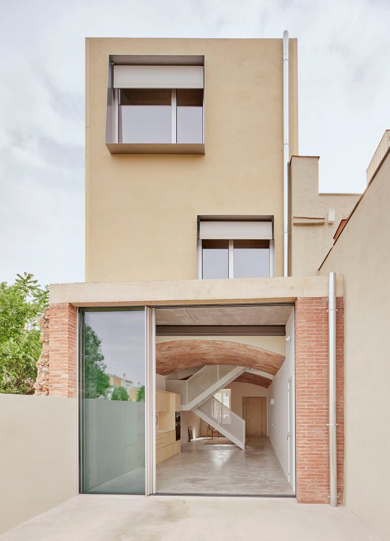 Facade with open glazed ground floor revealing vaulted brick ceiling and timber stair beyond