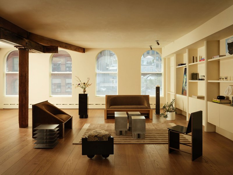 Open loft space with arched windows, exposed timber beams and warm afternoon light