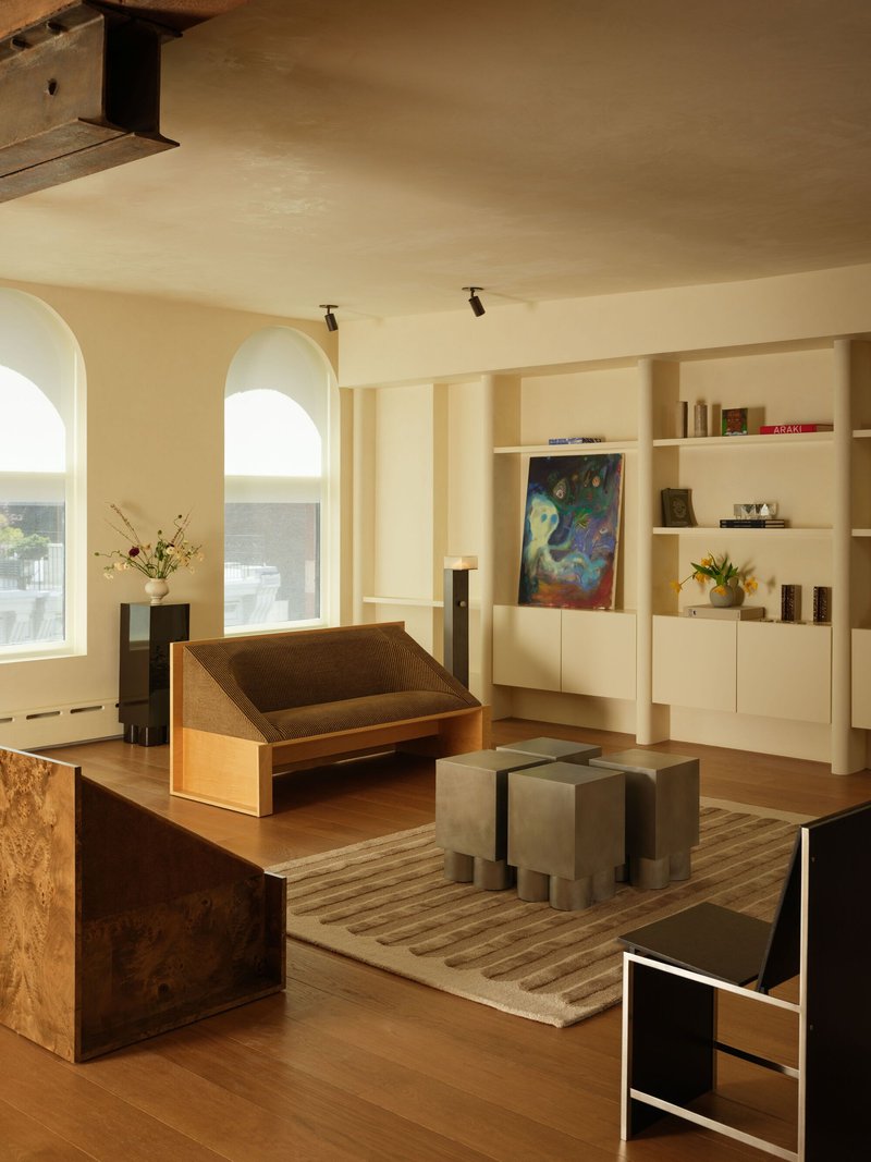 Living area with arched windows and burled wood furniture under painted ceiling