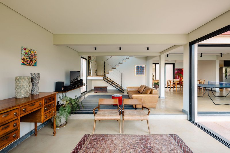 Open-plan living area with concrete floors and exposed steel staircase visible through doorway
