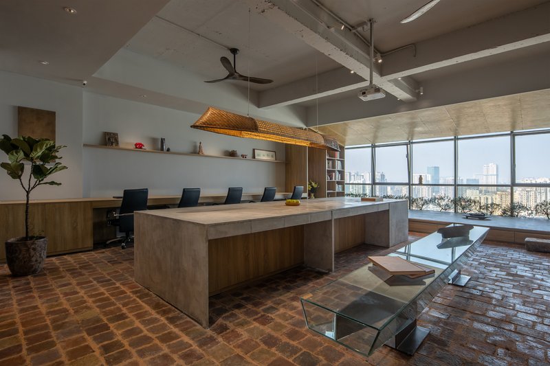 Conference table with woven pendant light and floor-to-ceiling windows overlooking the city skyline
