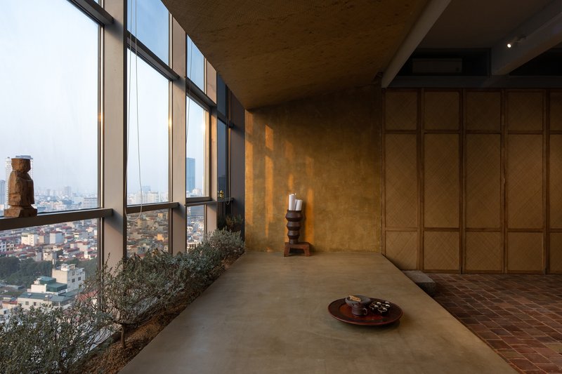 Interior corridor with floor-to-ceiling windows overlooking the cityscape and planted bed along the sill