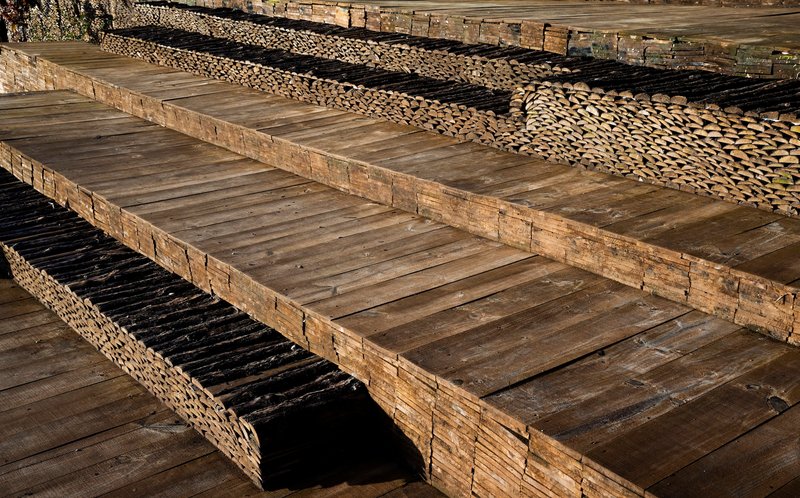 Close-up of tiered bamboo deck construction showing split poles and timber beams