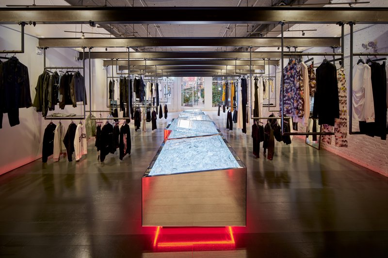 Retail floor with illuminated table runway extending toward street windows visible in the distance