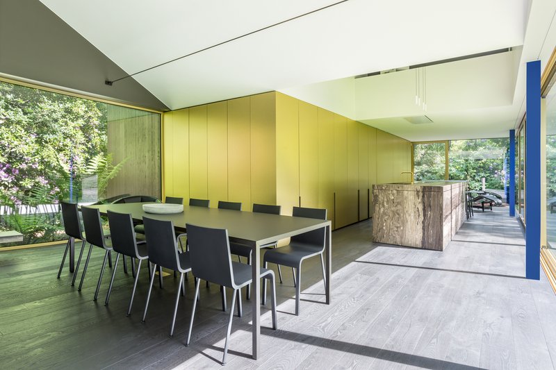 Dining area with brass-clad wall panels and sliding glass doors to an exterior deck