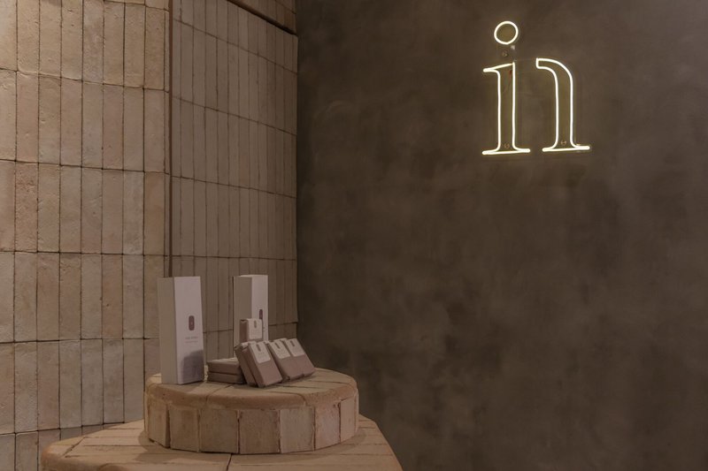 Neon numeral signage on concrete wall beside circular platform with dispensers and towels