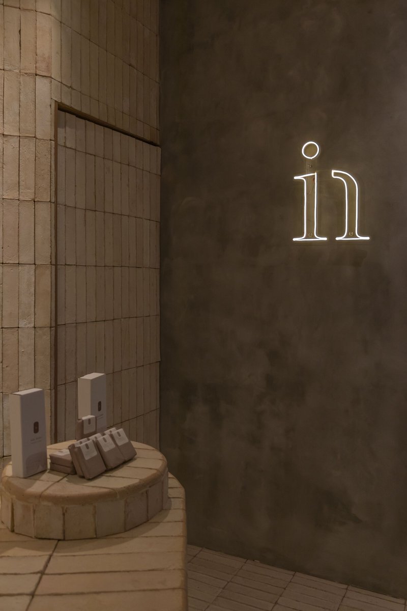Corner view showing wood-tiled wall meeting concrete with illuminated neon numerals