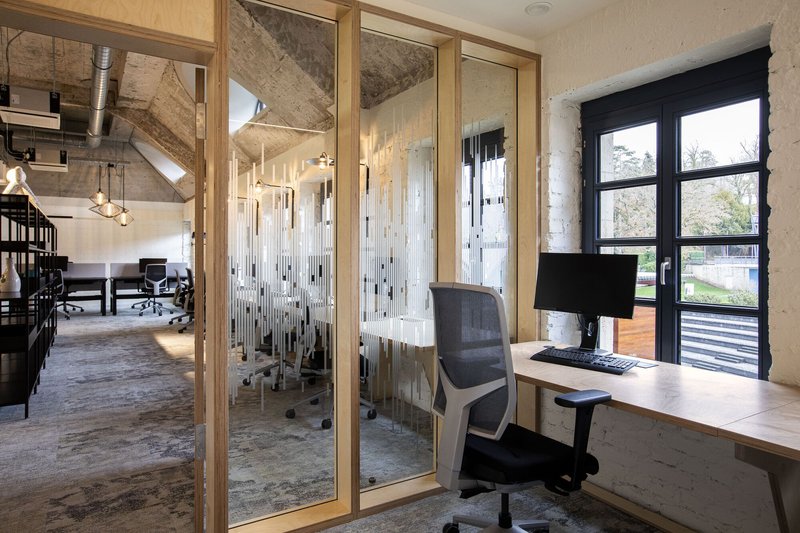 Workspace with timber-framed translucent partitions and a desk beside a black steel window