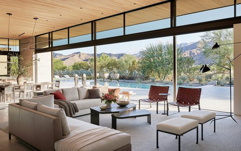 Living room with clerestory windows overlooking pool terrace and desert landscape