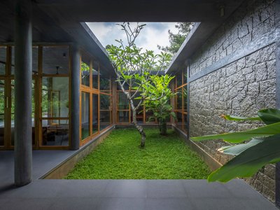 3dor Concepts Wraps a Kerala Home in Mirrored Concrete Arcs Around a Courtyard Tree