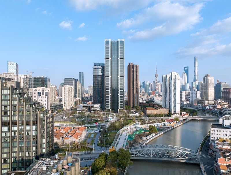 Twin towers with vertical glass and white louvered facades viewed across the waterfront in daylight