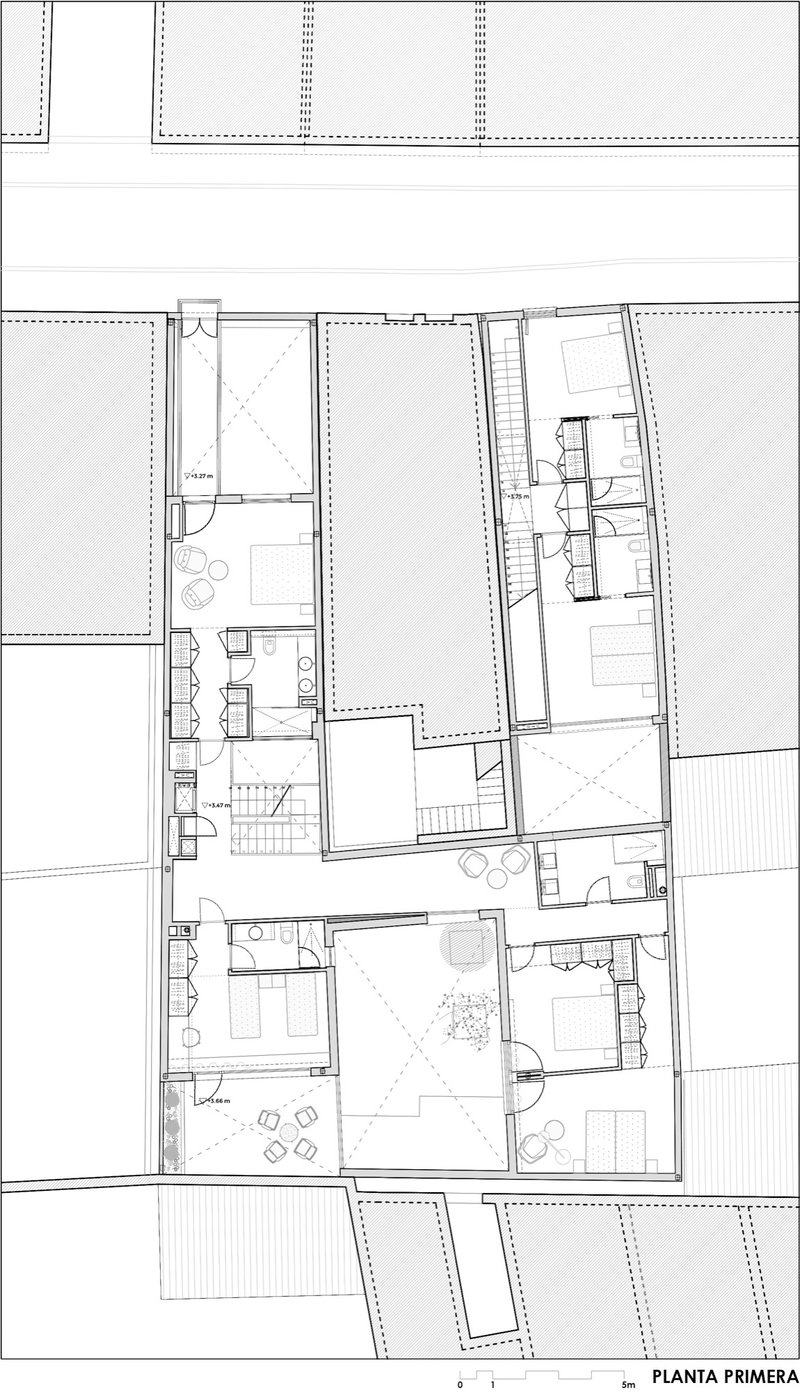 First floor plan drawing showing bedrooms, bathrooms, and terraces arranged around a central courtyard