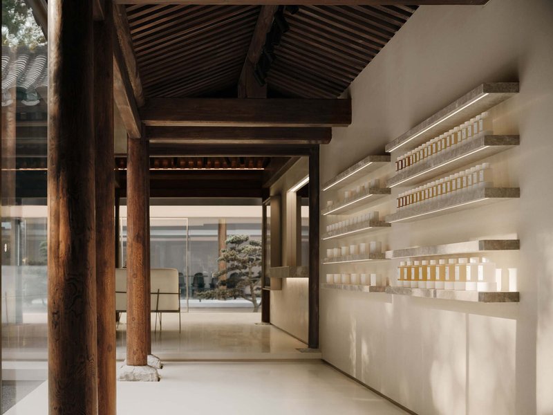 Interior with exposed timber beams and columns alongside illuminated product shelving along a white wall