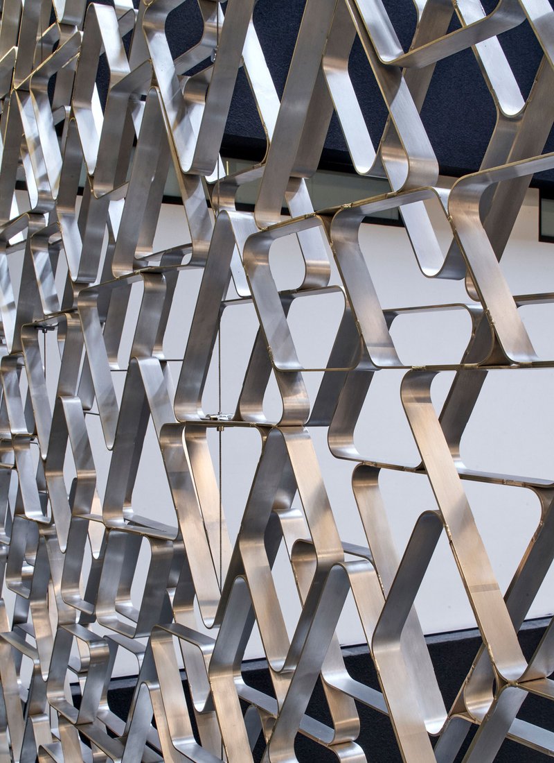 Close-up of the polished metal triangular screen surface catching daylight and shadow