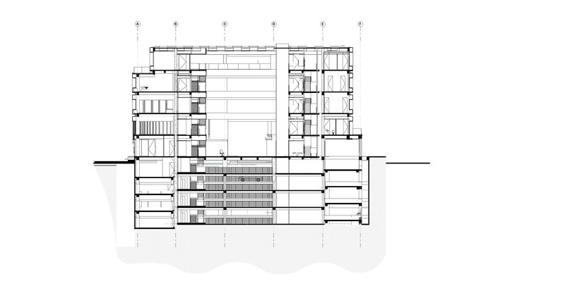Section drawing showing a central atrium with surrounding multi-story volumes and underground levels