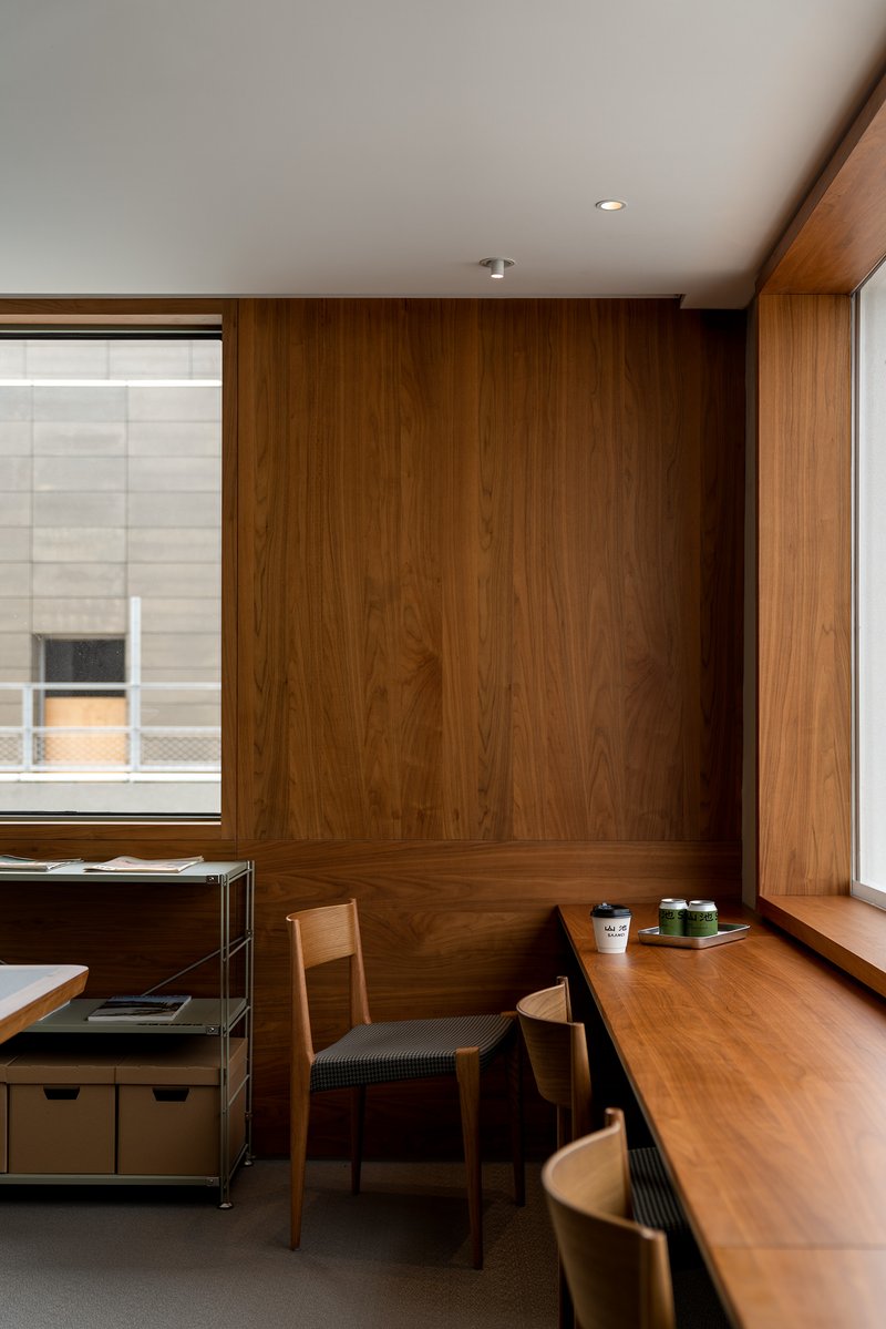 Corner banquette with timber wall paneling and a window sill holding ceramic cups