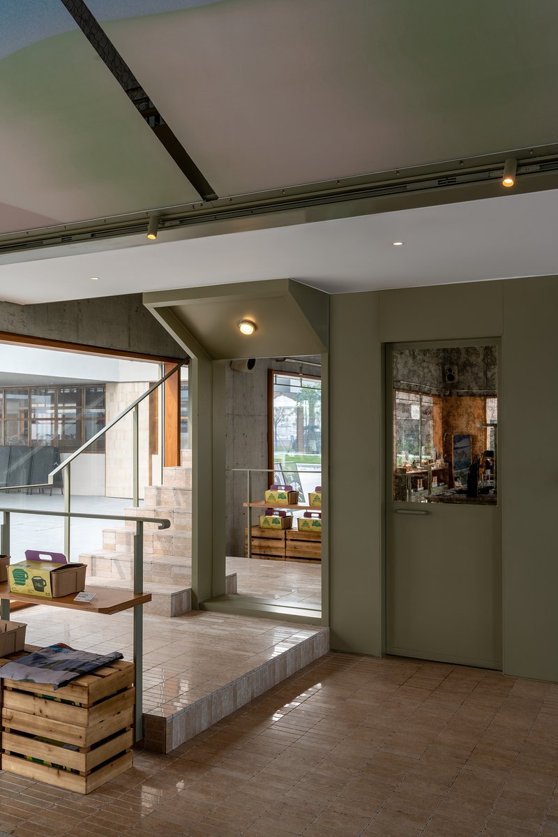 Split-level interior with concrete steps and timber flooring beneath a mezzanine with metal railing