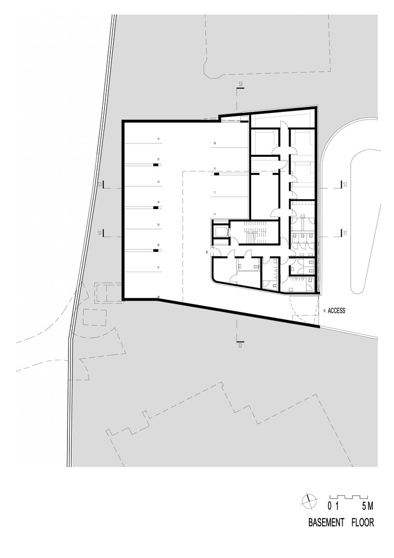 Basement floor plan showing a large open space with service rooms and access point along the angled perimeter
