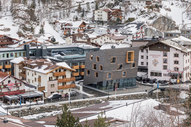 Elevated view of the shingled building set within a snow-covered alpine village