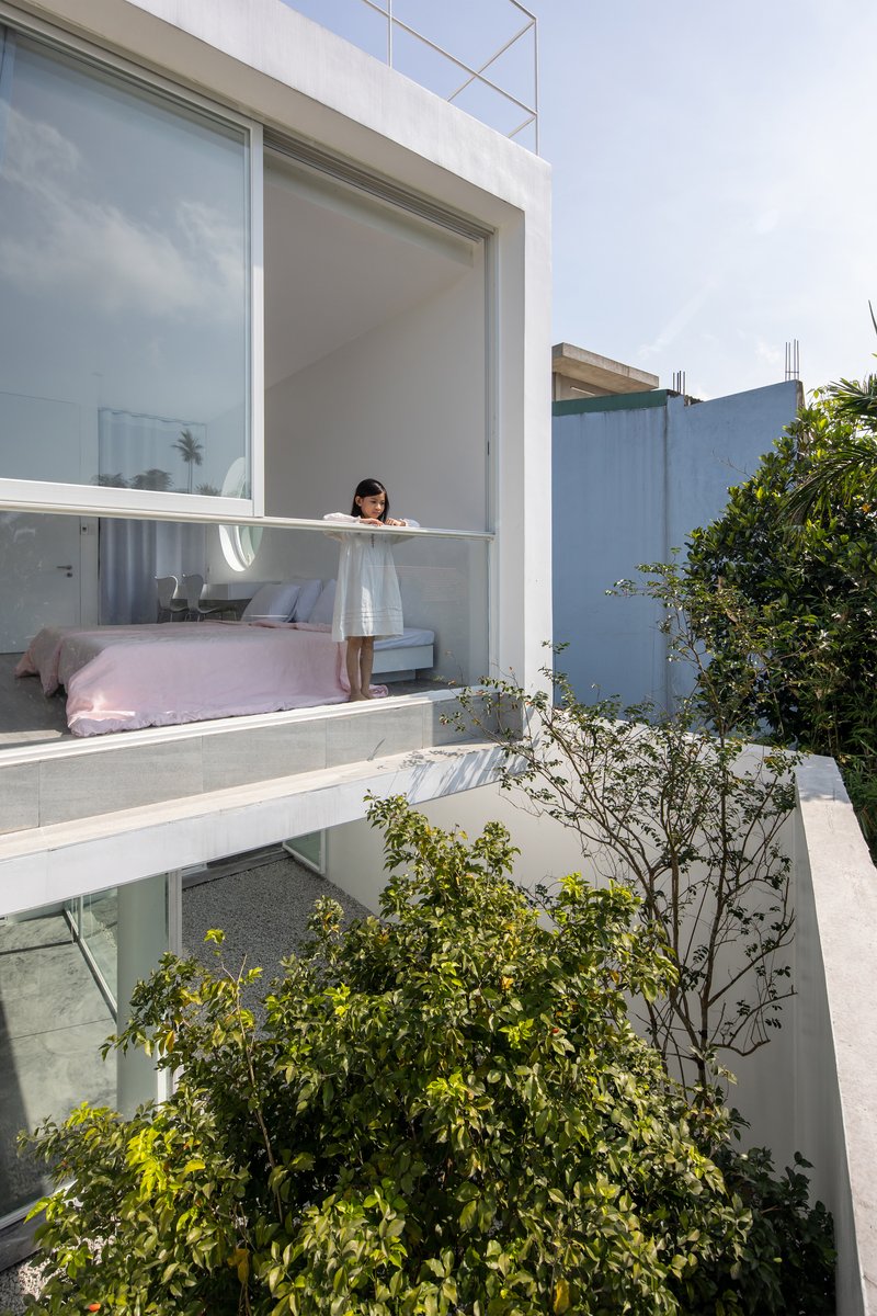 Exterior view of stacked balconies with sliding glass doors and planted terraces below