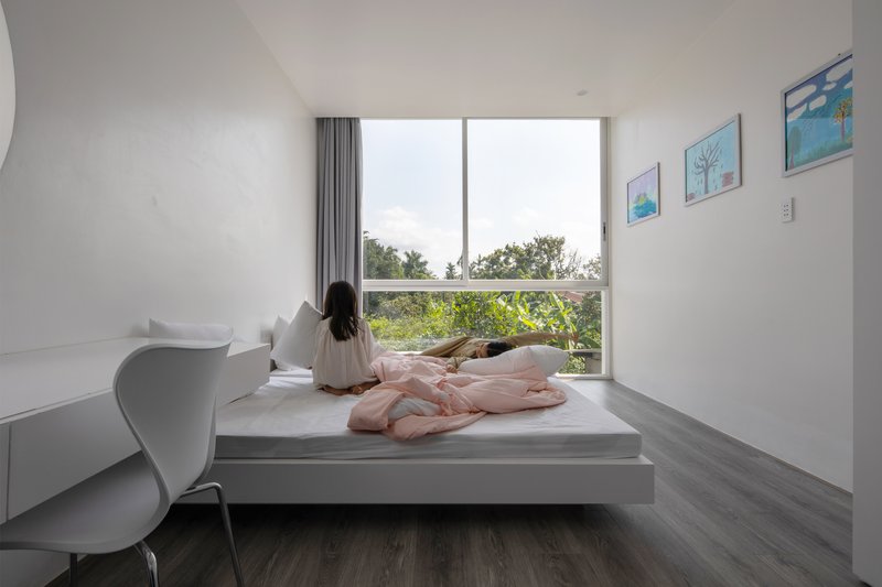 Window seat nook with a seated figure looking out toward trees in daylight